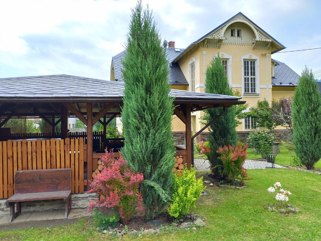 um gazebo e um banco em frente a uma casa em Vila Liduška 