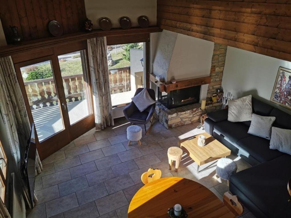 vistas panorámicas a una sala de estar con sofá y chimenea en Ferienwohnung im Haus Soldanella en Obersaxen