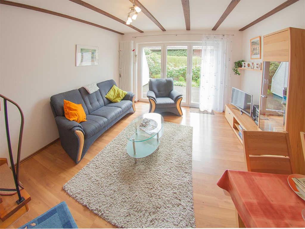 a living room with a couch and a table at Ferienhaus Seedeich, FeWo Vermittlung Nordsee in Dangast