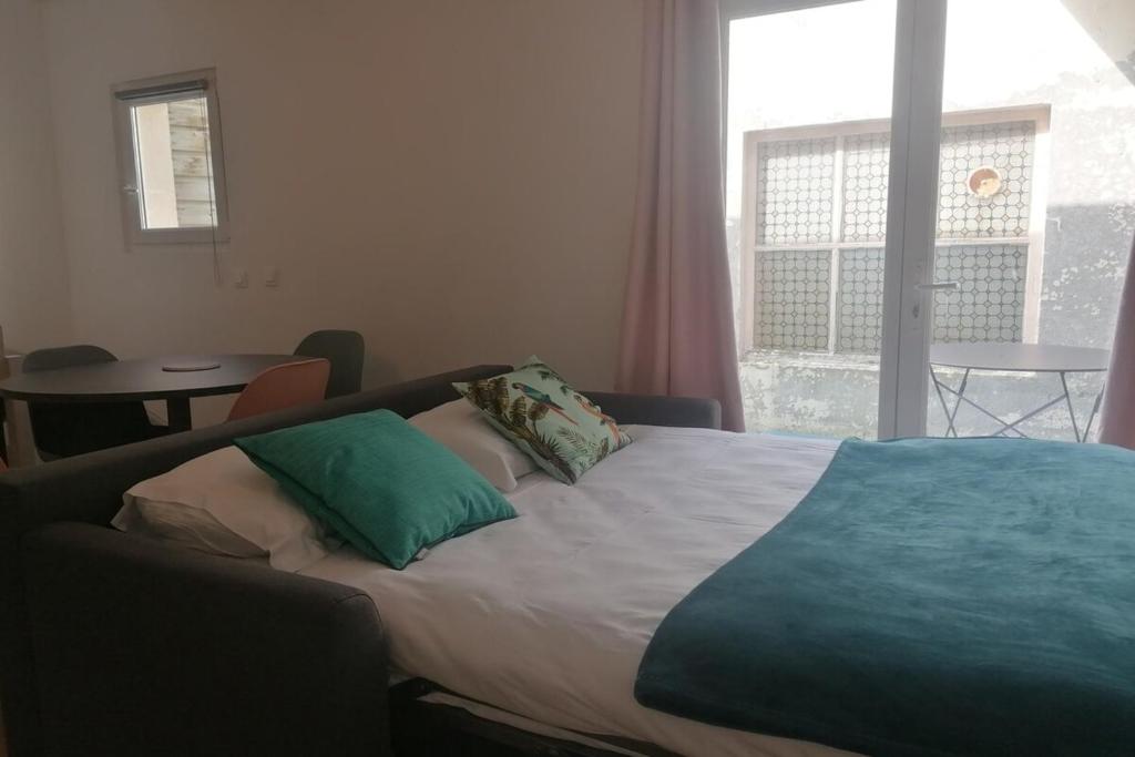 een bed met twee kussens in een slaapkamer bij Joli duplex calme avec terrasse centre Paimpol in Paimpol