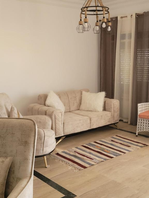 a living room with a couch and a chandelier at Northcoast coral hills in Zāwiyat al ‘Awwāmah