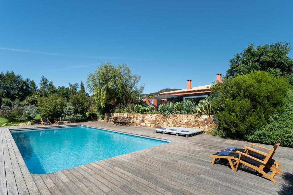 uma piscina com um banco e uma casa em Garden Seaside Villa by CadenzaLux em Cascais