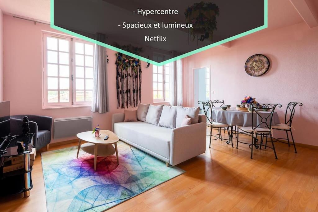 uma sala de estar com um sofá e uma mesa em Le Rose poudré - Spacieux et lumineux- Hypercentre em Lisle-sur-Tarn