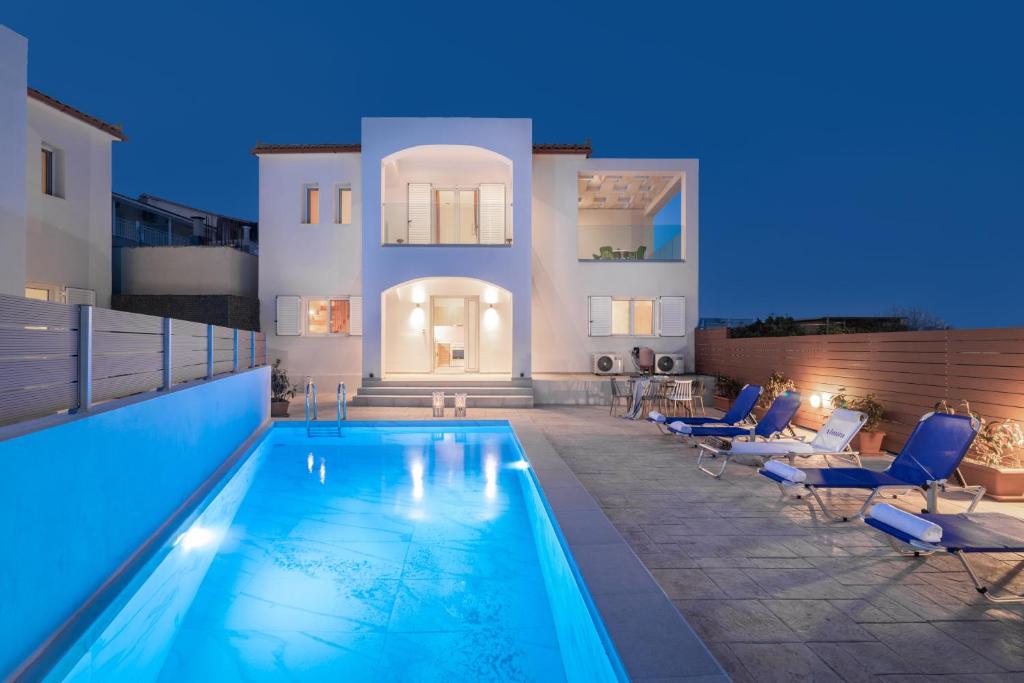 a villa with a swimming pool at night at Astarte Villas - Ocean Pool Villa in Tsilivi