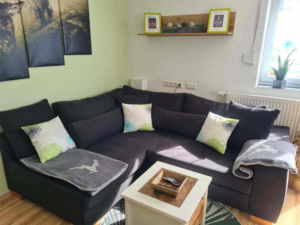 ein Wohnzimmer mit einem blauen Sofa und einem Tisch in der Unterkunft Ferienwohnung 's Stüble in Schönwald