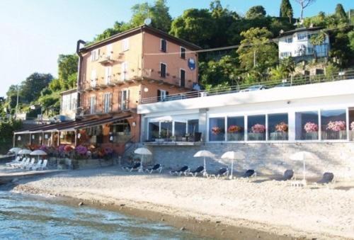 a group of birds sitting on a beach next to a building at Hotel Beata Giovannina in Verbania
