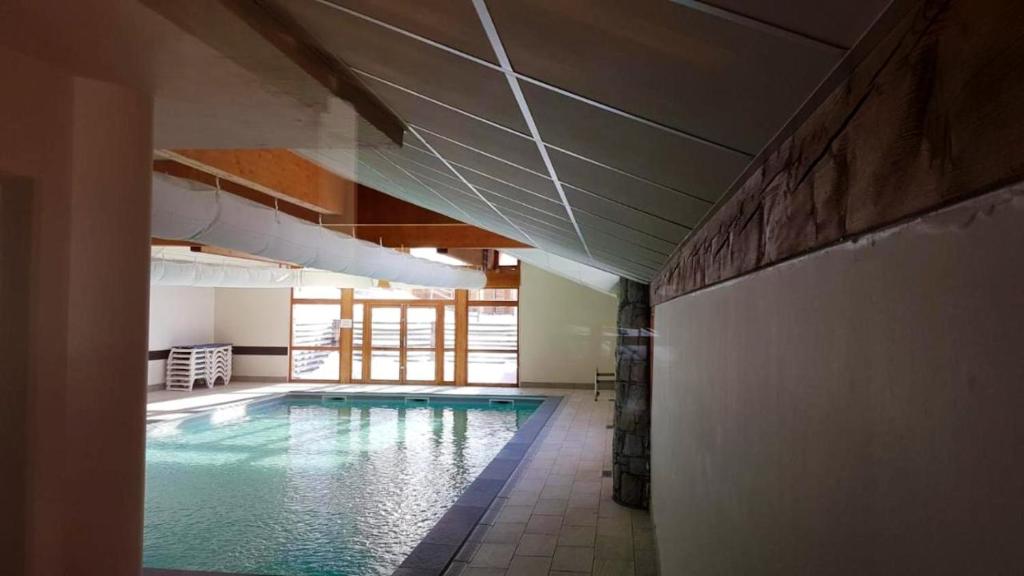 una gran piscina en un edificio con piscina en Chalet de 4 chambres a Valmeinier a 500 m des pistes avec piscine partagee sauna et balcon, en Valmeinier