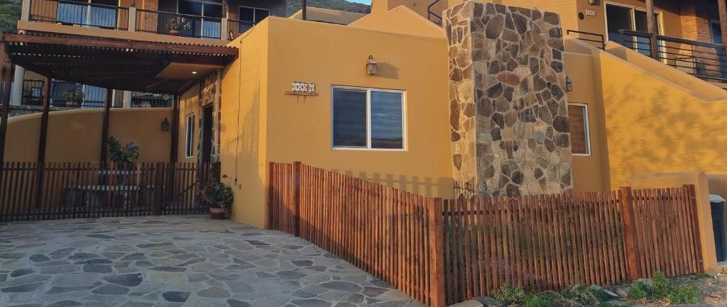 une maison jaune avec une clôture devant elle dans l'établissement Adorable Casita w/Estuary & Ocean Views, à Ensenada