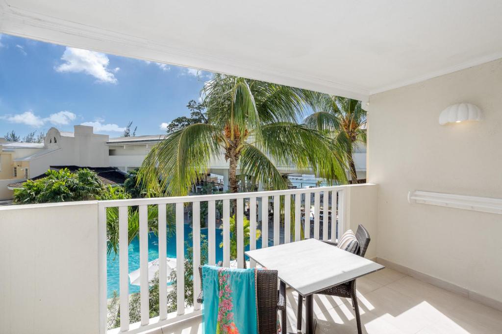 a balcony with a table and a view of the pool at Sugar Bay Barbados - All Inclusive in Bridgetown