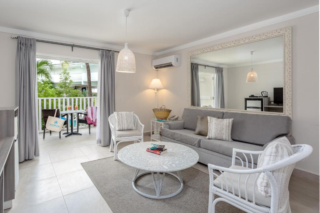 a living room with a couch and a table at Sugar Bay Barbados - All Inclusive in Bridgetown