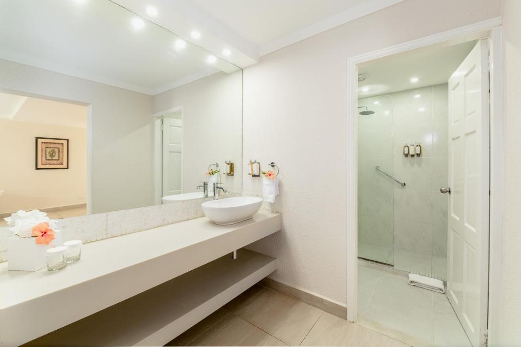 a white bathroom with a sink and a shower at Sugar Bay Barbados - All Inclusive in Bridgetown