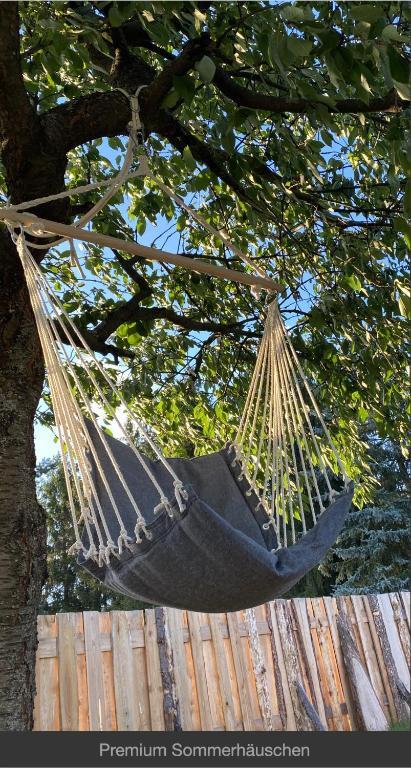 a black hammock hanging from a tree at Sommerhäuschen in Rheinsberg