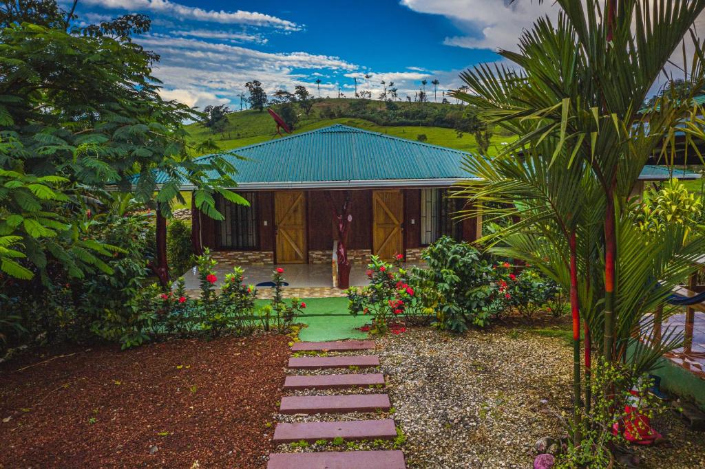 un jardín con una pasarela frente a una casa en Rio Celeste Springs Blue Lodge en Bijagua
