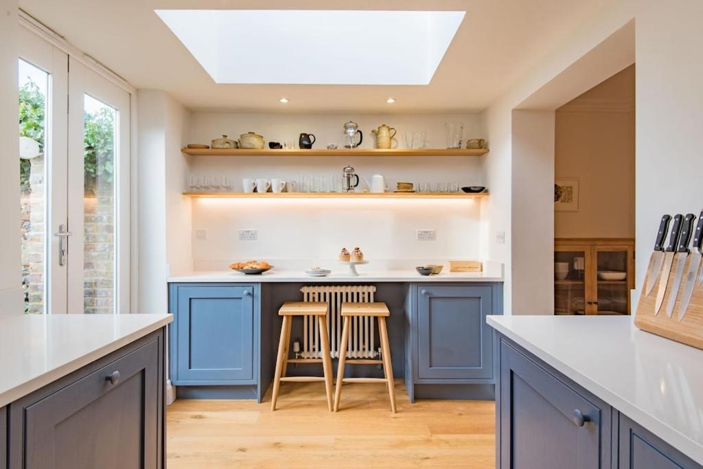 a kitchen with blue cabinets and a skylight at Liberty Cottage in Broadstairs