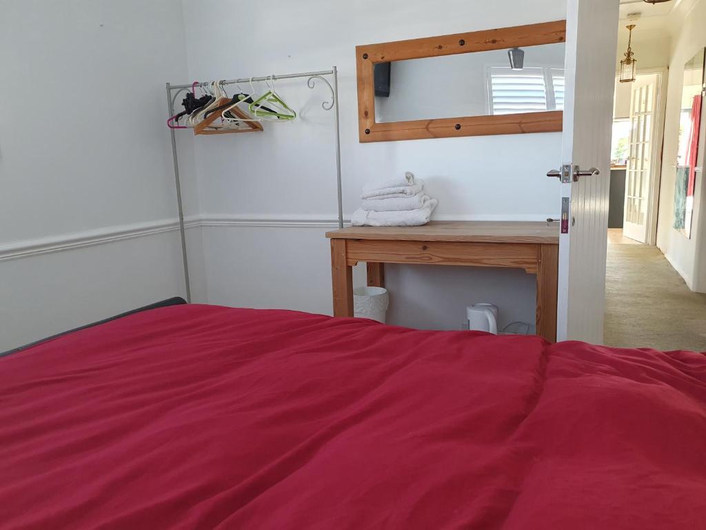 a bedroom with a red bed and a desk at 30 Heath Estate in Great Waldingfield