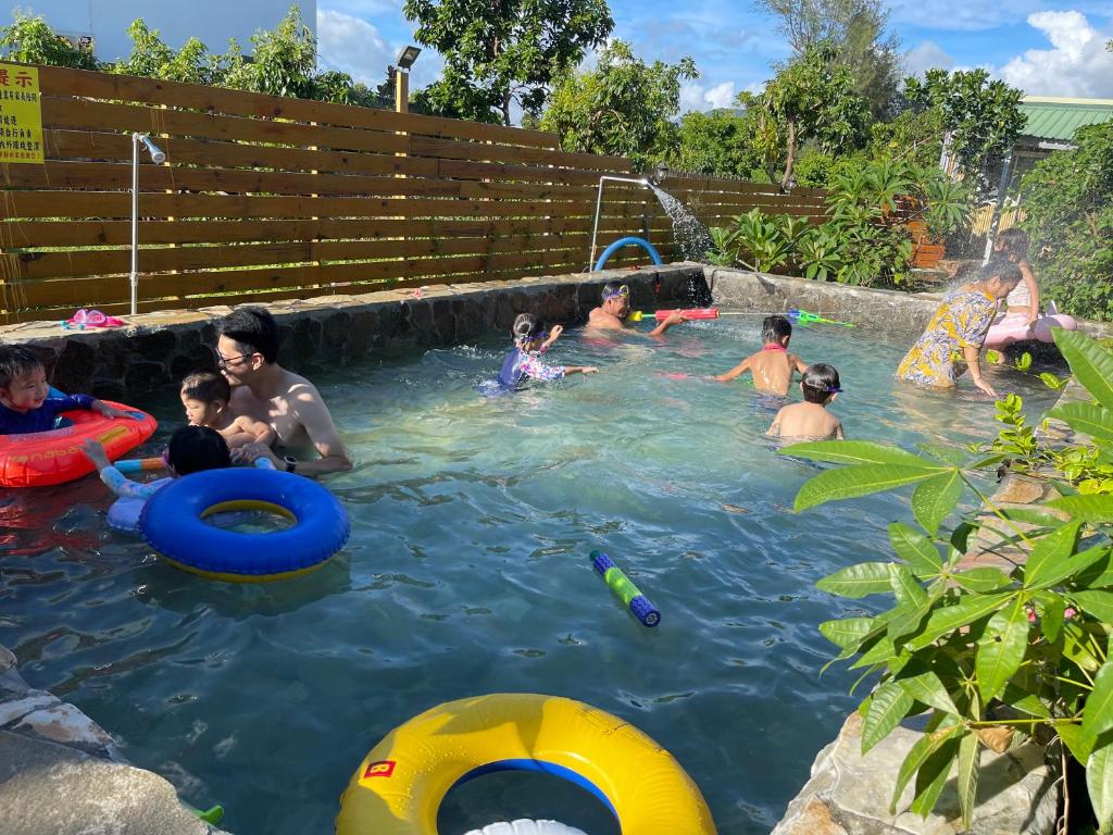 a group of people playing in a swimming pool at 寧靜的家14人Villa獨立設施包棟戲水池烤肉區麻將廚房私人停車場 in Hengchun South Gate