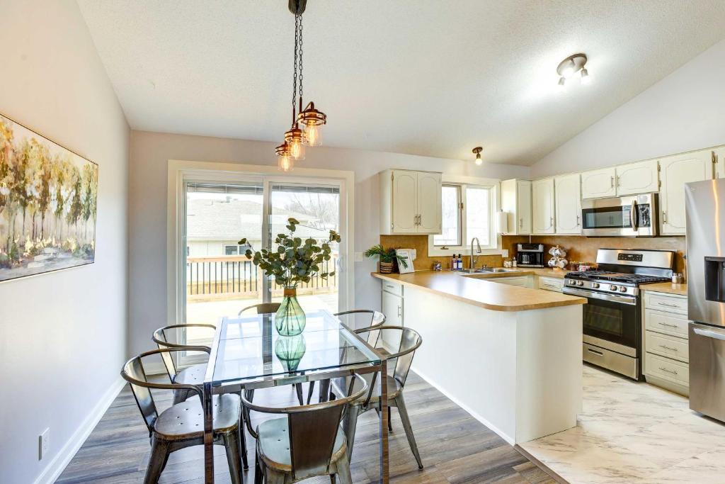 a kitchen with a glass table with chairs and a counter at Pet-Friendly Omaha Vacation Rental with Deck! in Omaha
