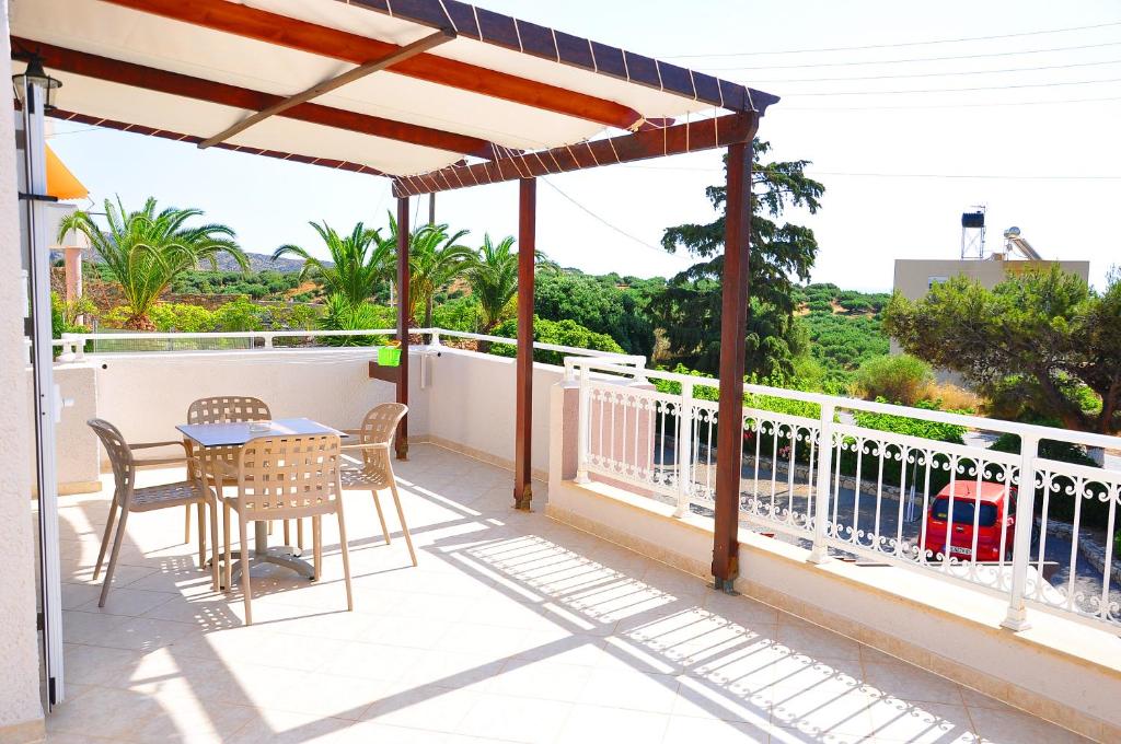 a patio with a table and chairs on a balcony at Lagos Studios & Apartments in Palekastron