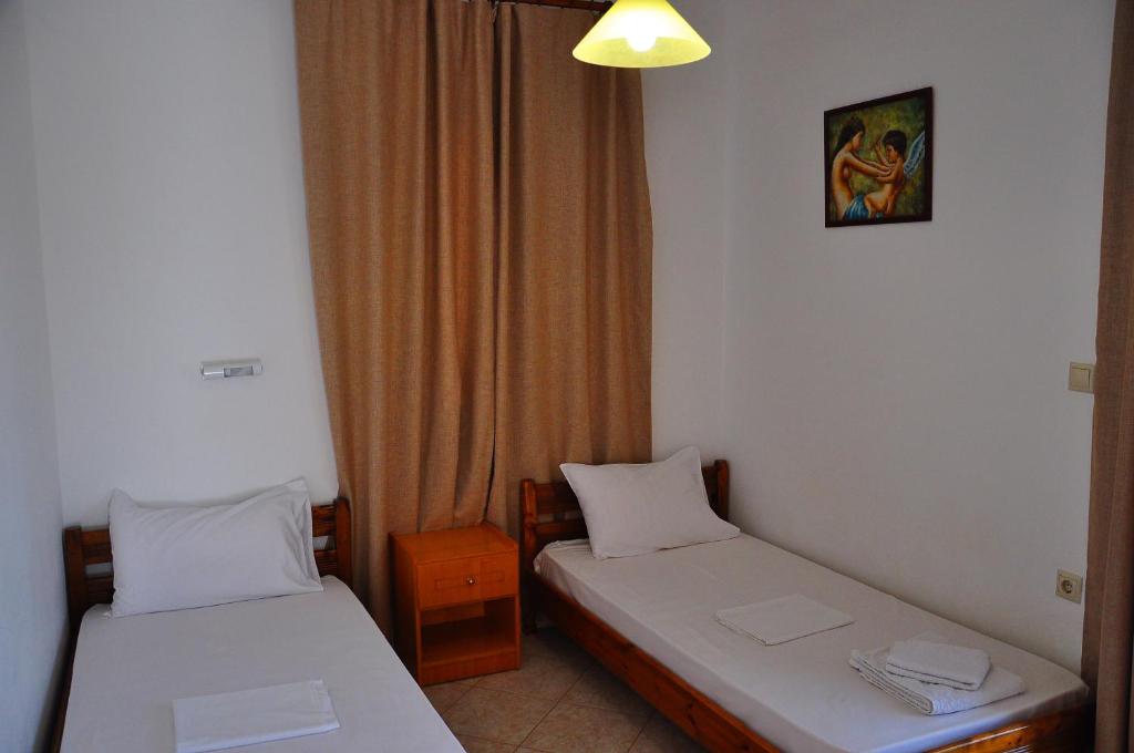 a room with two beds and a window at Lagos Studios & Apartments in Palekastron