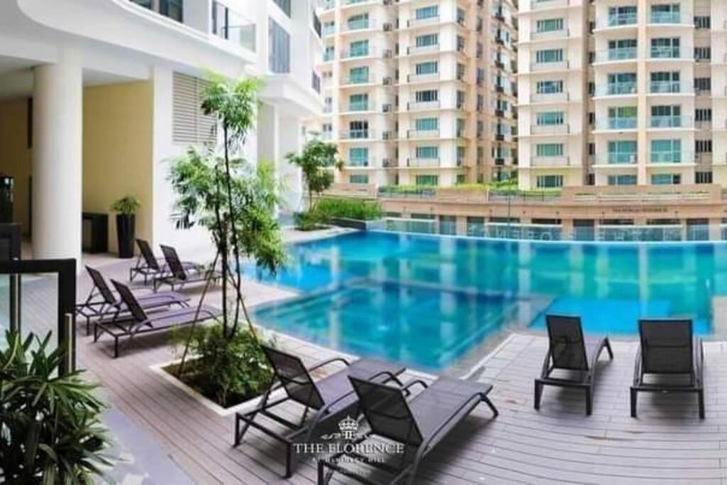 una piscina con sillas y un gran edificio en McKinley Hills BGC Taguig City Condo, en Manila