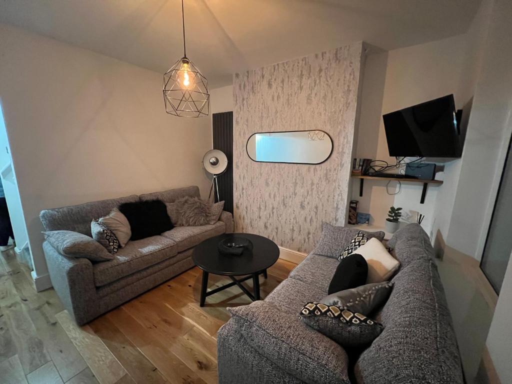 uma sala de estar com dois sofás e uma televisão em Centrally located in city of Lincoln Idas Place - two bedrooms each with a kingsize bed em Lincolnshire