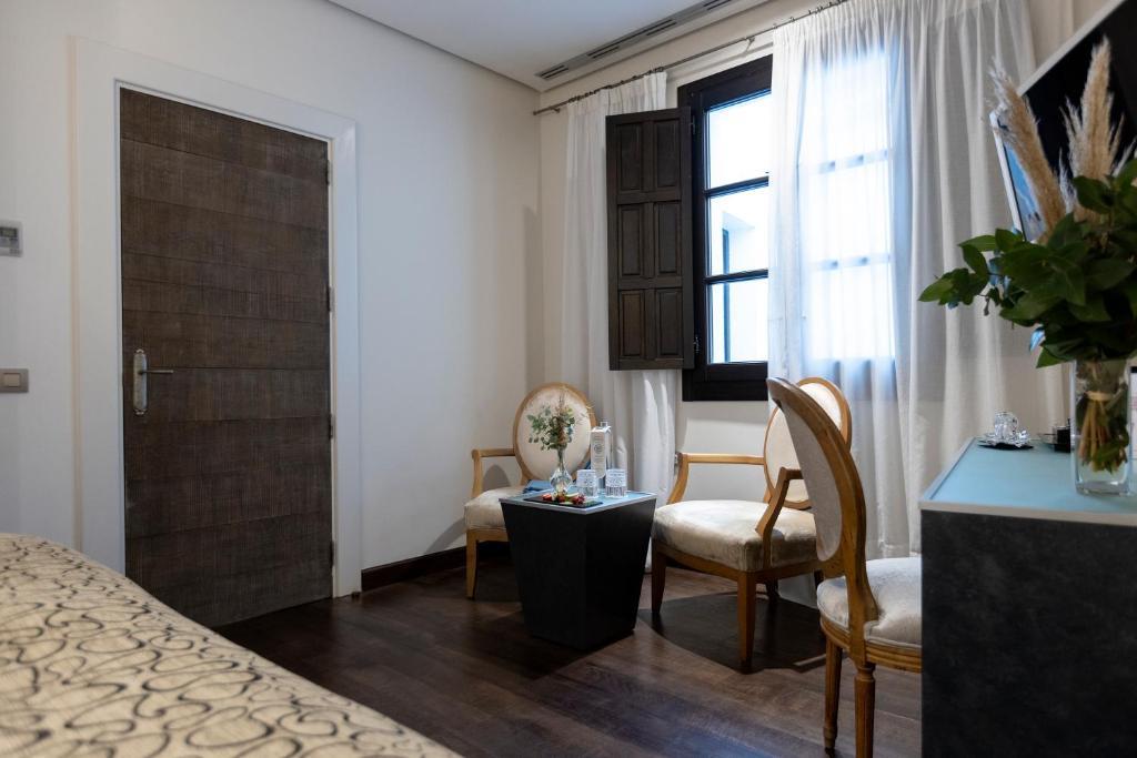 a bedroom with a bed and a table and chairs at Hospes Palacio del Bailio, a Member of Design Hotels in Córdoba