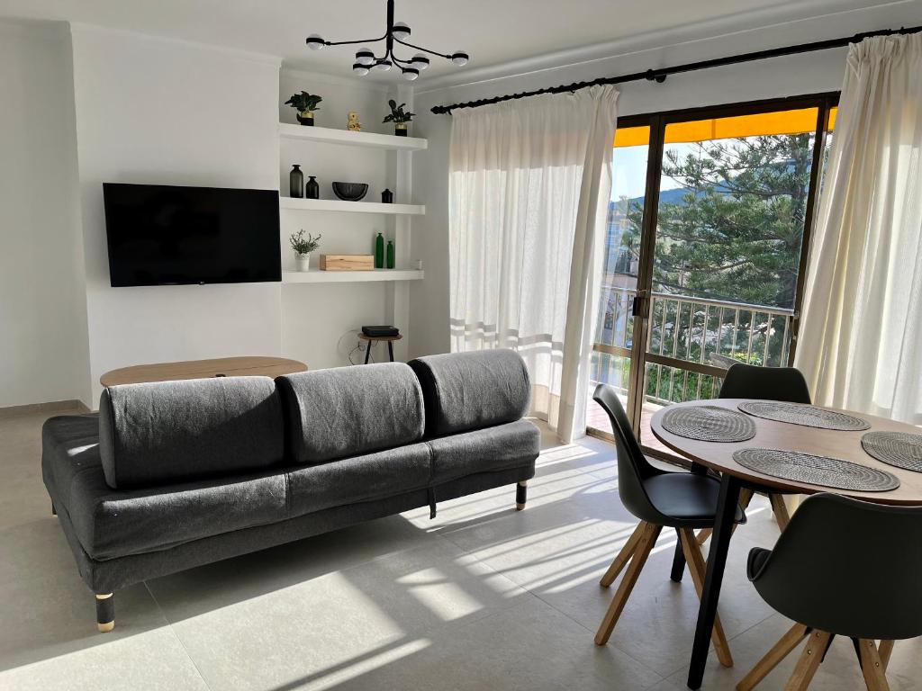 ein Wohnzimmer mit einem Sofa und einem Tisch in der Unterkunft Apartamento Cala Ratjada. Recién reformado in Cala Ratjada