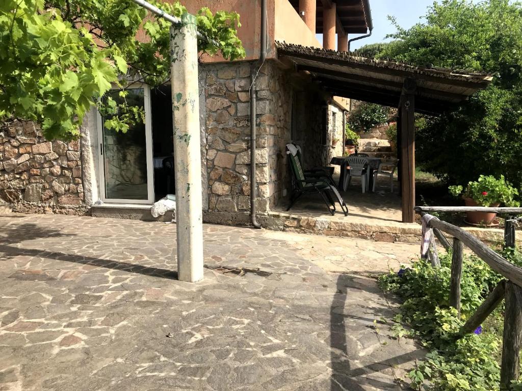 una casa de piedra con una mesa y una silla al aire libre en Villa Ederle en La Maddalena