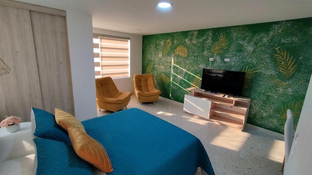 Schlafzimmer mit einem Bett und einem Flachbild-TV in der Unterkunft PARK 66 Apartaestudios in Cali