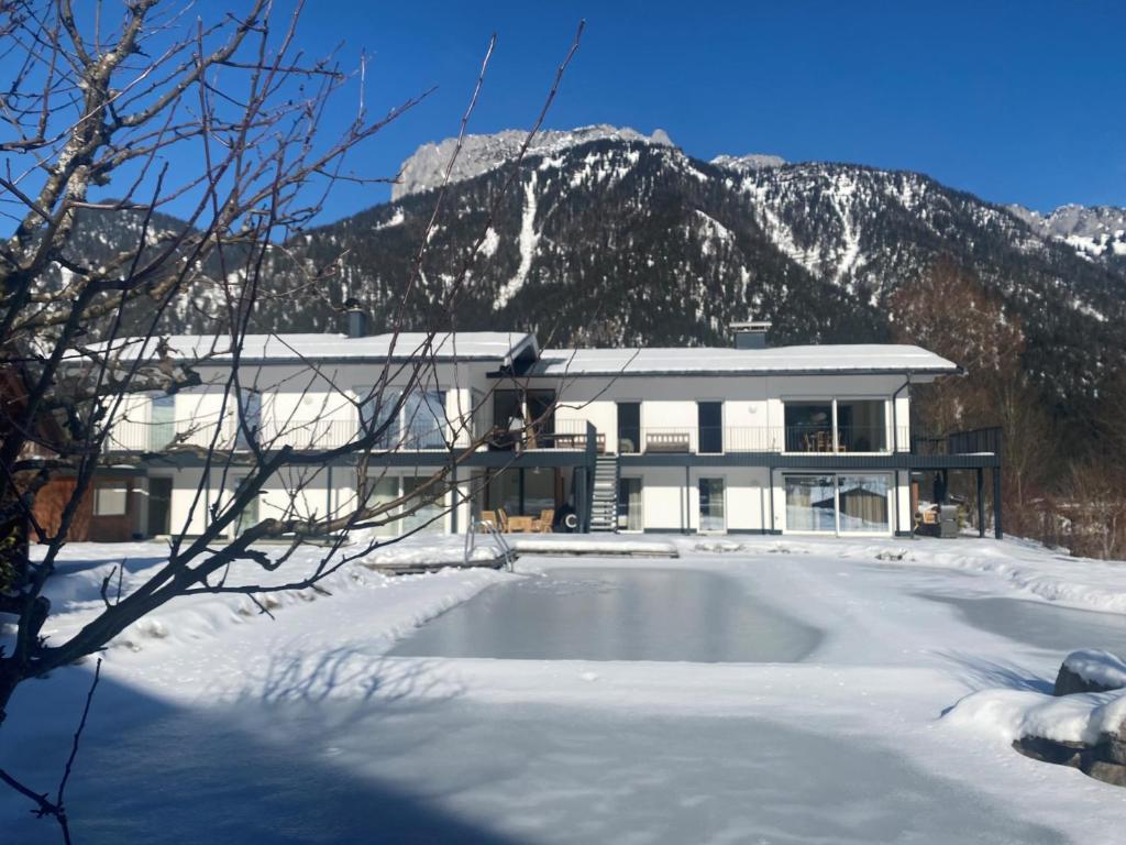 ein Haus im Schnee vor einem Berg in der Unterkunft Apartment Steinplatte in Waidring