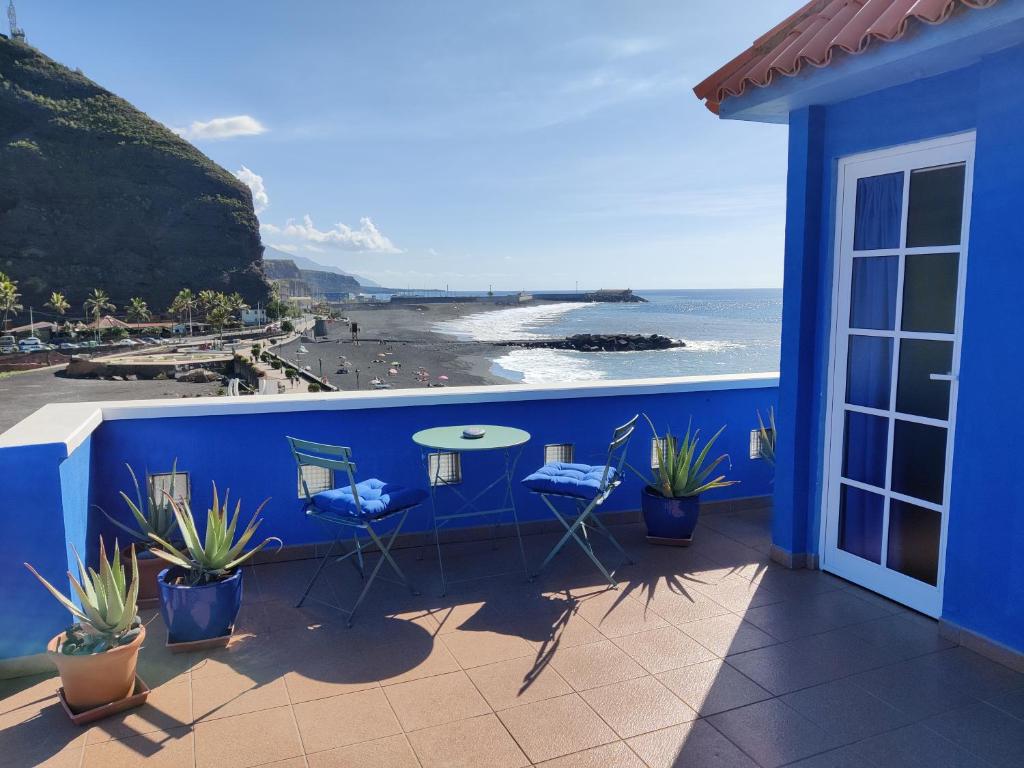 un balcón azul con mesa, sillas y el océano en Dachterrassenwohnung Puerto Tazacorte en Puerto