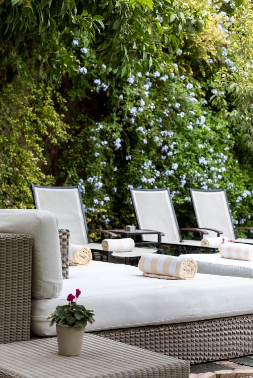 a group of chairs sitting on a patio at Hospes Palacio del Bailio, a Member of Design Hotels in Córdoba
