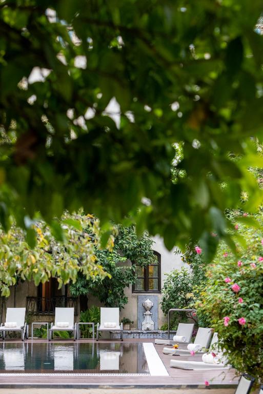 a group of chairs and a table in front of a building at Hospes Palacio del Bailio, a Member of Design Hotels in Córdoba