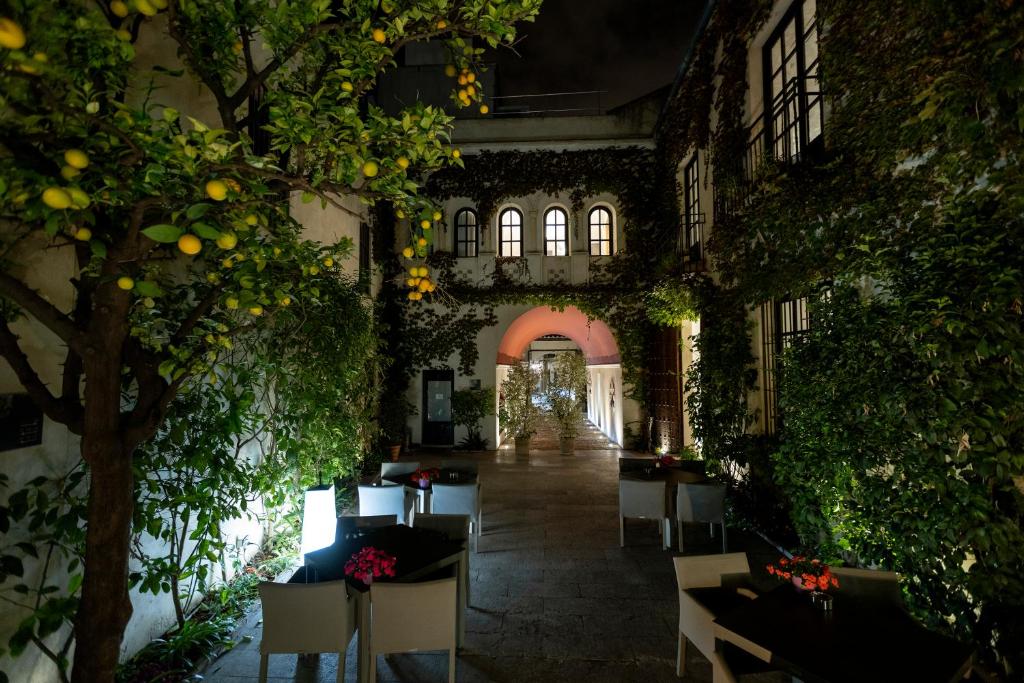 a building with a hallway filled with plants and tables at Hospes Palacio del Bailio, a Member of Design Hotels in Córdoba