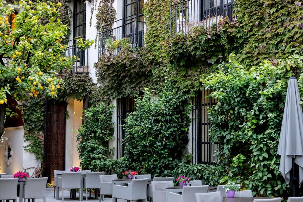 an outdoor dining area with tables and an umbrella at Hospes Palacio del Bailio, a Member of Design Hotels in Córdoba