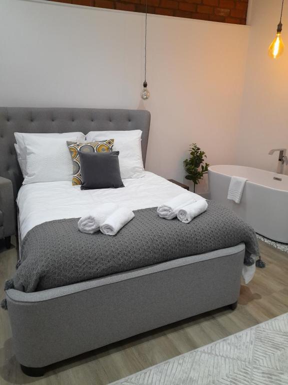 1 dormitorio con cama, bañera y lavamanos en Orchard Lane Great Glen Unique 2 bed cosy home en Great Glen