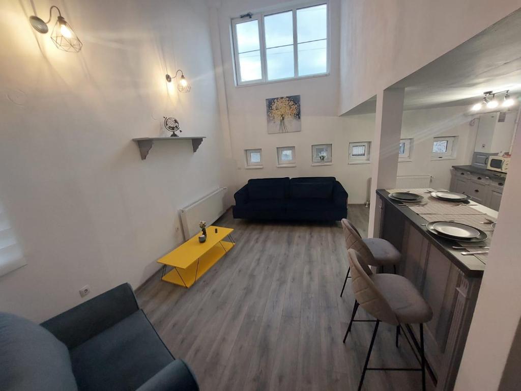 een woonkamer met een blauwe bank en een gele tafel bij The One in Sighişoara