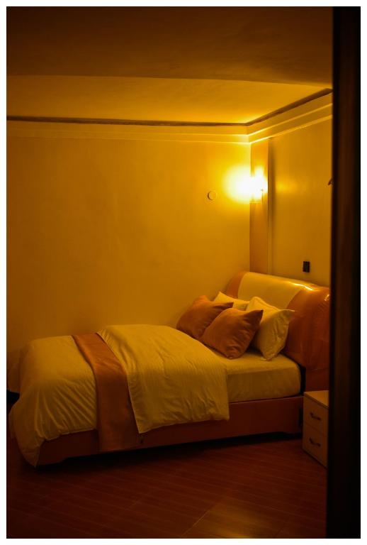 a bedroom with two beds with a light on the wall at Ruby Haven in Kampala