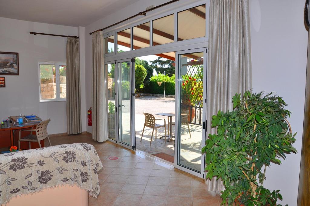 a living room with a sliding glass door with a table at Lagos Studios & Apartments in Palekastron