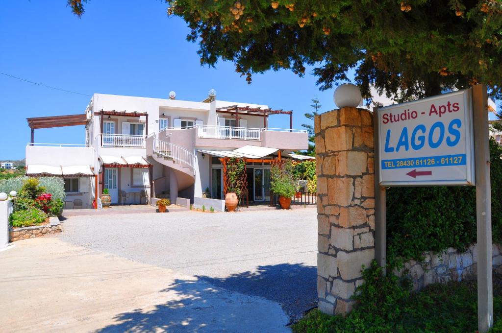 una señal frente a un edificio con una casa en Lagos Studios & Apartments en Palekastron