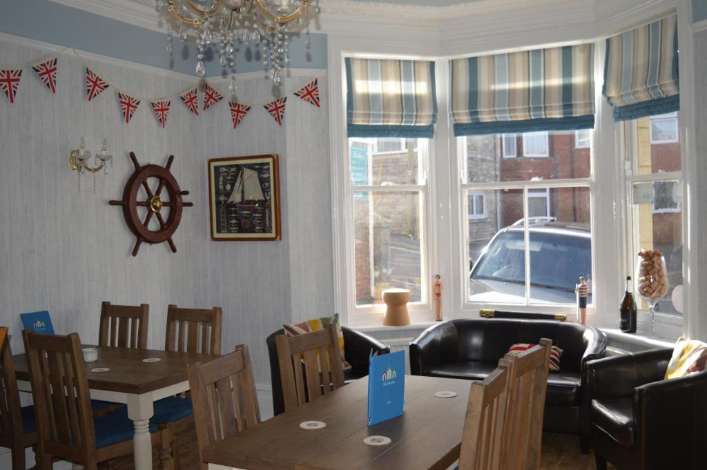 uma sala de jantar com mesa e cadeiras e uma sala de jantar em The Rookery em Swanage