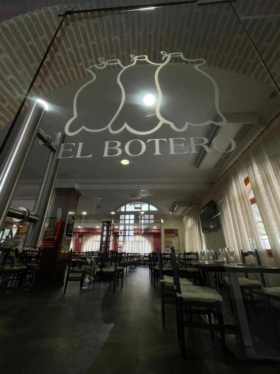 Un comedor con mesas y sillas en un restaurante. en Hostal El Botero, en Monreal del Campo