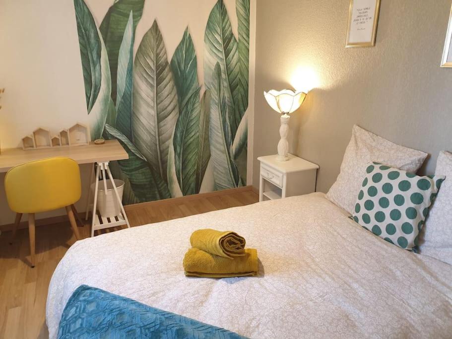 sypialnia z łóżkiem z żółtym ręcznikiem w obiekcie Cosy Opal 2CH - Terrasse & Stationnement gratuit w mieście Pau