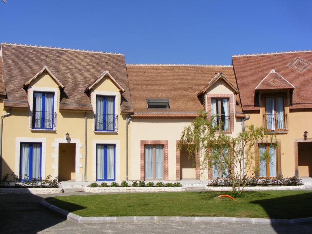 a large yellow house with brown roof at Les Belleme Golf - Self-catering Apartments in Bellême