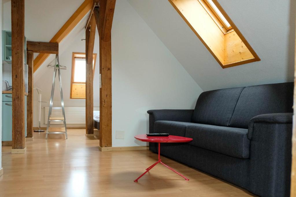 sala de estar con sofá y mesa roja en Spatzennest, en Spiez
