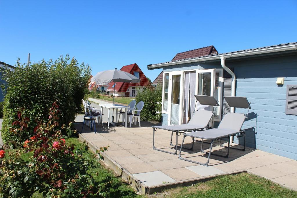 un patio con sedie e tavoli accanto a una casa di MP 8 - Deichgraf 2 Komfort a Dorum-Neufeld