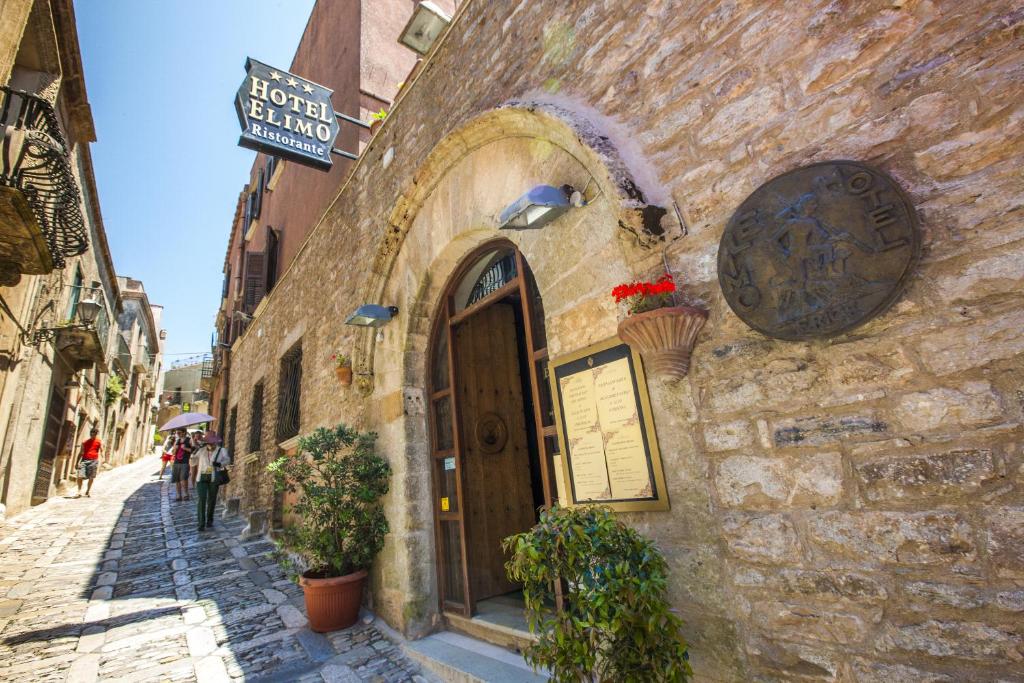 un edificio de piedra con una puerta en una calle en Hotel Elimo, en Erice