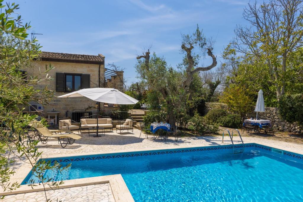 a villa with a swimming pool and a house at Casa Ulmi con piscina in Uggiano la Chiesa