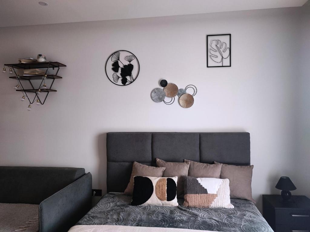 ein Schlafzimmer mit einem grauen Bett mit Kissen darauf in der Unterkunft NLux46 Milmari in Kopaonik