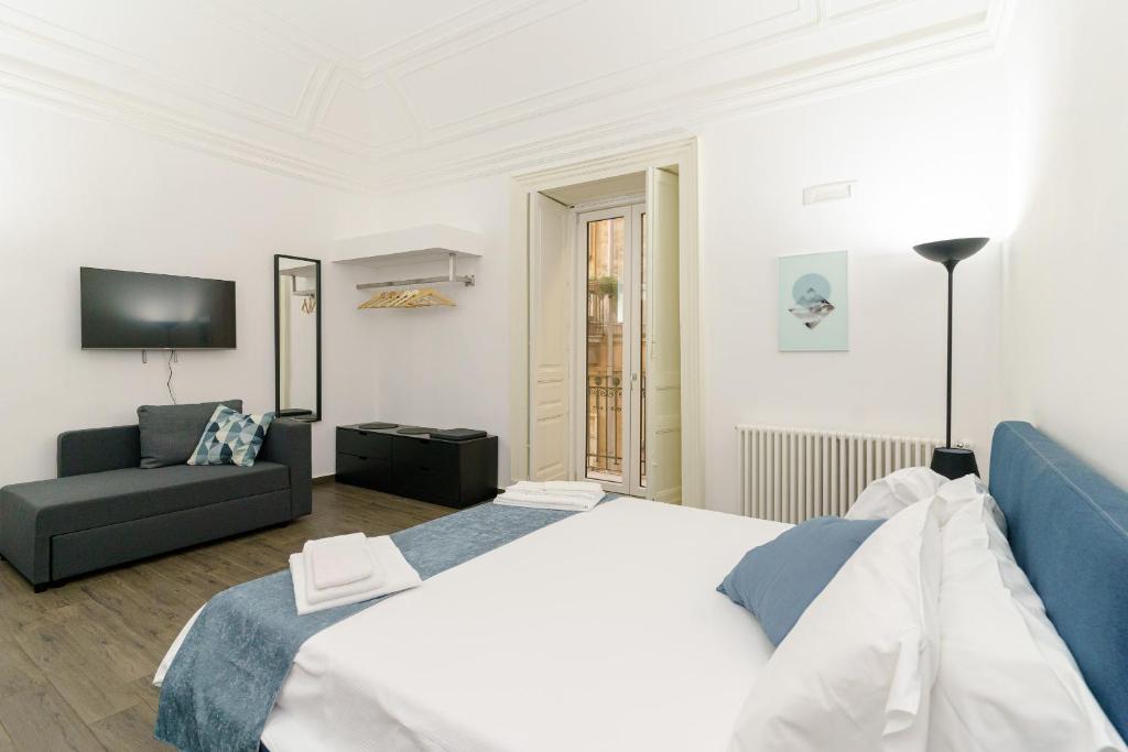 Un dormitorio con una cama grande y un sofá. en SiSTO18, en Catania